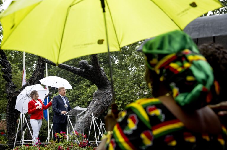 Het weer is regenachtig. Koning Willem-Alexandere bij Nationale Herdenking Slavernijverleden.